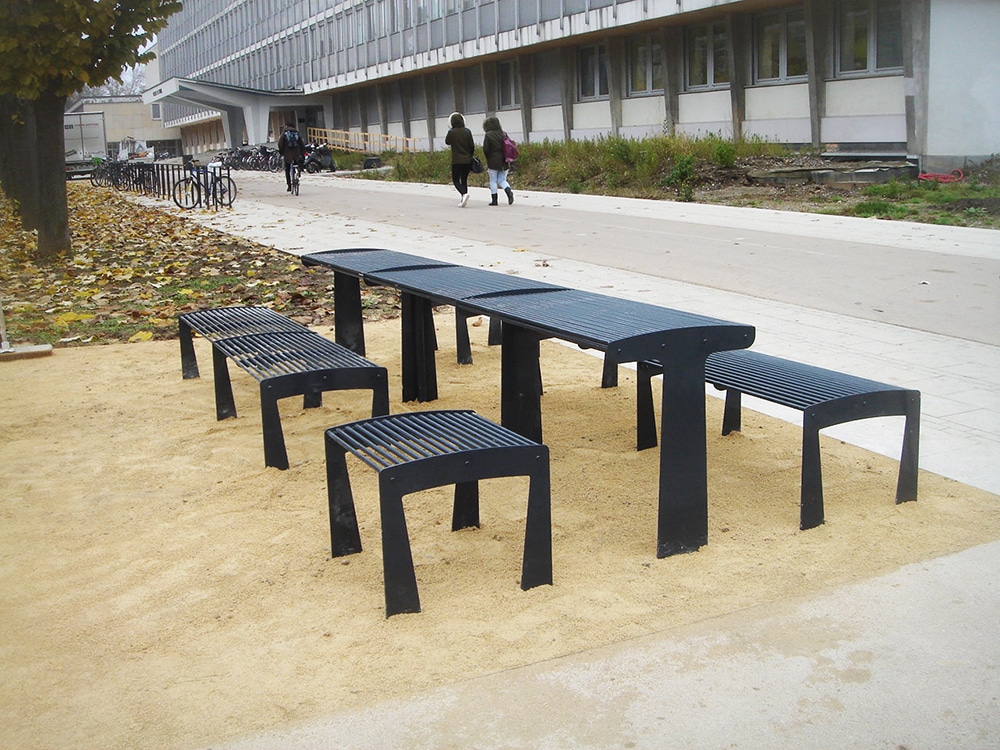Une photographie de vraies tables TUB grises avec des tabourets et des banquettes TUB grises